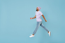 Full Length Side View Of Young Confident Excited Happy Unshaven Black African Man In Violet T-shirt Hat Glasses Jump High Walk In Air Going Isolated On Pastel Blue Color Background Studio Portrait.