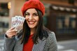 © Krakenimages.com - Young hispanic woman smiling happy holding russian ruble banknotes at the city.