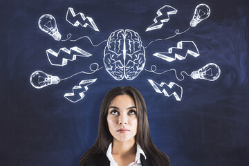 Wall Mural - Decision and thinking concept with businesswoman in front of blackboard with chalk sketch of human brain parts, lightning strike symbols and light bulbs