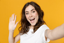 Close Up Young Excited Smiling Friendly Cool Caucasian Woman 20s In White Basic Casual Tshirt Do Selfie Shot On Mobile Phone Waving Hands Say Hello Isolated On Yellow Color Background Studio Portrait