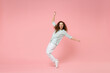 © ViDi Studio - Full length young black african american happy smiling friendly curly woman in blue shirt look camera standing on toes leaning back dancing have fun isolated on pastel pink background studio portrait.