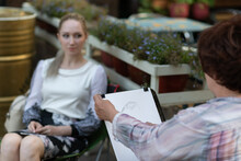 Artist Draws A Portrait Of A Young Woman.