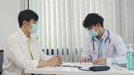 Wall Mural - Doctors are explaining the treatment of a patient's illness while wearing a mask during the epidemic.