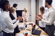 © Roman - Concentrated business people applaud their colleague after the presentation in the board room
