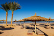 deserted empty beach, sun loungers and umbrellas on the shores of the Red Sea, evening, winter Sharm El Sheikh, Egypt