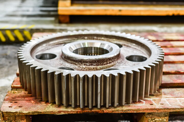 Cogwheel wheel on a wooden rack in a warehouse.