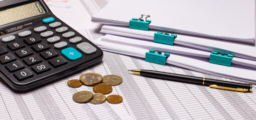 On the desktop there are reports, calculator, cash and pen. Business concept. Flat lay