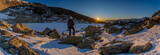 Fototapeta Góry - panoramic view of the sunrise or sunset of the sun over the mountains with a snow lake with a unrecognized person