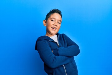 Wall Mural - Little boy hispanic kid wearing casual sporty jacket happy face smiling with crossed arms looking at the camera. positive person.