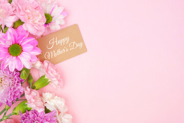 Aufkleber - Happy Mothers Day gift tag with side border of pink and white flowers. Top view on a pink background. Copy space.