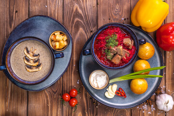 Wall Mural - Soup in the assortment, tomatoes, spices on a brown wooden background.