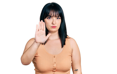 Sticker - Young hispanic plus size woman wearing casual clothes doing stop sing with palm of the hand. warning expression with negative and serious gesture on the face.