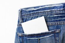 Back Pocket With Blank Paper On White. Closeup Of A Sheet Of Blank Paper With Space For Text In A Pocket Of Jeans.