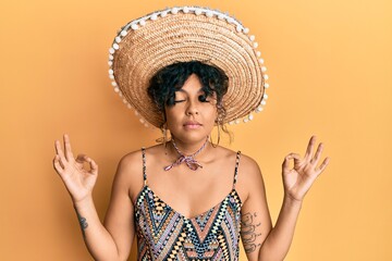 Poster - Young hispanic woman holding mexican hat relax and smiling with eyes closed doing meditation gesture with fingers. yoga concept.