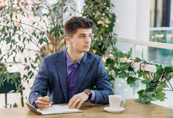 Handsome man in a blue suit. Businessman working in a cafe