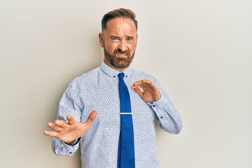 Poster - Handsome middle age man wearing business shirt and tie disgusted expression, displeased and fearful doing disgust face because aversion reaction. with hands raised