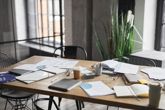 Background image of wooden table with documents scattered on after business meeting in office, copy space