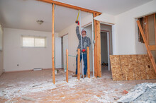Carpenter Measuring A Demolished Room