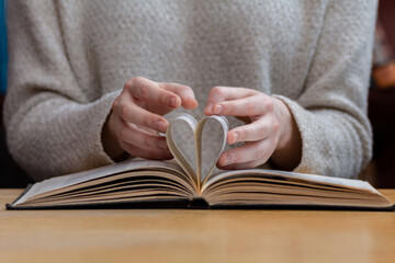 woman folded the pages of the book in the shape of a heart, Concept-education