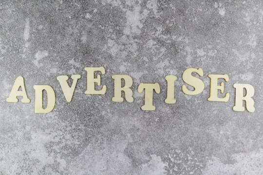 Advertiser concept with decorative alphabet letters in an undulating line on a textured grey background viewed as a flat lay with copyspace