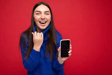 woman wearing casual stylish clothes standing isolated over background with copy space holding and using mobile phone looking to the side and shouting