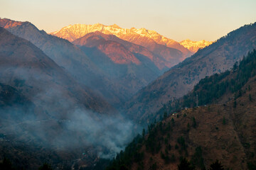 Wall Mural - sunset rays over the snow capped mountain peaks, pekhri, tirthan valley, himachal pradesh, india