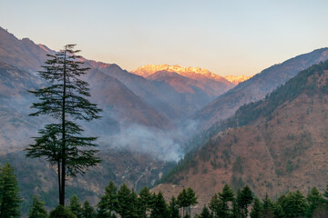 Wall Mural - sunset rays over the snow capped mountain peaks, pekhri, tirthan valley, himachal pradesh, india