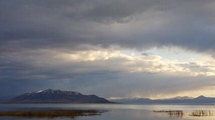 Wall Mural - Time lapse of storm clouds moving over Utah Lake at dusk.