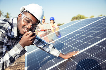 two workers technicians installing heavy solar photo voltaic panels to high steel platform in corn f