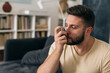 © cherryandbees - man using asthma pump at home