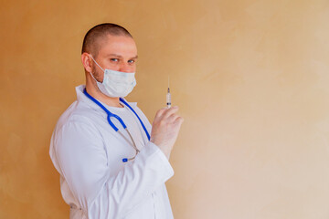 Man doctor holding syringe.  Doctor in surgical mask and gloves  preparing syringe for injection during covid-19 pandemic