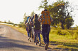 © Studio Romantic - Group of young hikers walk in a row along the road with backpacks on their shoulders.