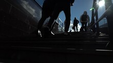 Legs Of A Young Man Climbing The Stairs From The Subway Up Against A Clear Blue Sky On A Sunny Day.