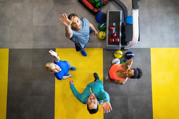 Wall Mural - Young sporty people working out together with kettle bells in a gym.