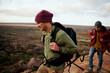 © StratfordProductions - Two male friends with backpack and winter cap climbing mountain