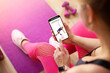© Kaspars Grinvalds - Woman uses fitness app on her phone for working out at home