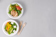 Two diet light salads with chicken, tomatoes, avocado, greens, white background. Healthy lunch. Take away food in eco paper plates. Concept restaurant delivery, environment protection. Copy space