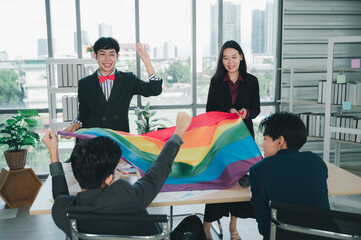 Wall Mural - Group of LGBTQ businessmen with a rainbow flag in hand are having fun with their colleagues inside the office. The concept of diversity, race and culture, the concept of anti-sexism.