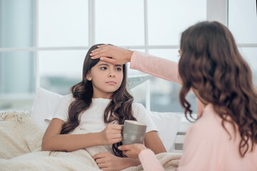 Wall Mural - Mom with back to camera touching daughters forehead