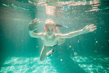 Cute Little Boy Underwater In Swimming Pool 