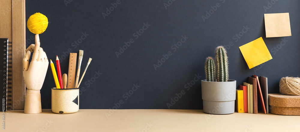 Creative desk with a blank picture frame or poster space, desk objects, office supplies, books, and plant on a dark blue background.	 - obrazy, fototapety, plakaty 