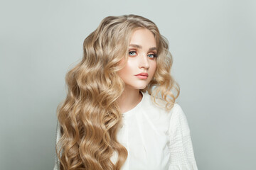 Wall Mural - nice woman with healthy blonde curly hairdo on white background