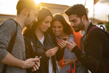 Wall Mural - Young people watching smartphone screen using social media application together - focus on the hands holding the cellphone