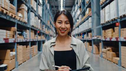 Wall Mural - Portrait of attractive young Asia businesswoman manager smiling charmingly looking at camera hold digital tablet stand in retail shopping center. Distribution, Logistics, Packages ready for shipment.