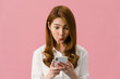 © tirachard - Young Asia lady using phone with positive expression, smiles broadly, dressed in casual clothing feeling happiness and standing isolated on pink background. Happy adorable glad woman rejoices success.