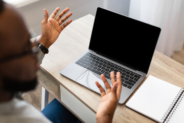 Wall Mural - African Businessman Talking To Laptop Empty Screen In Office, Mockup