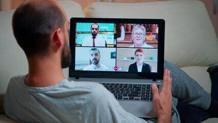 Poster - Focused adult using laptop computer during videocall conference talking about social business connection while sitting on couch. Relaxed man working at online communication project overtime in kitchen