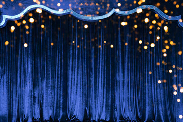 The blue curtain made of luxurious velvet on the stage of the theater is fantastically glittering