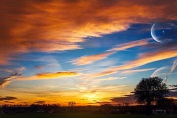 Wall Mural - beautiful dark fluffy cloudy sky with sun rays . crescent moon with beautiful sunset background