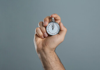 Sticker - Man holding vintage timer on grey background, closeup